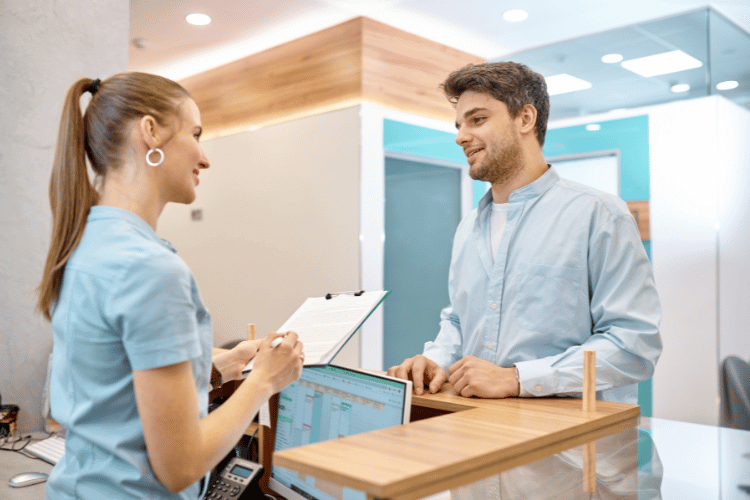 Man Talking to Professional Receptionist in Clinic